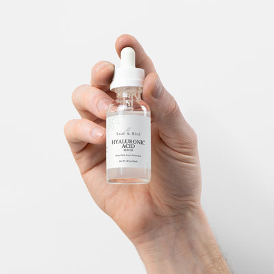 Hand holding the Leaf & Bird Hyaluronic Acid Serum bottle