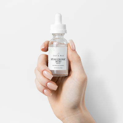 Hyaluronic Acid Serum bottle held between fingers