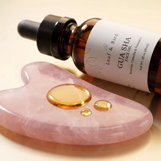 Gua Sha Face Oil texture: golden oil drops on a rose quartz gua sha stone
