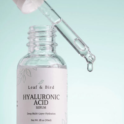 Clear hyaluronic acid gel dripping from the dropper above the open serum bottle